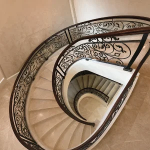 European Indoor Wrought Iron Curved Stair Railing with Black Ornate Panels and Wood Handrail